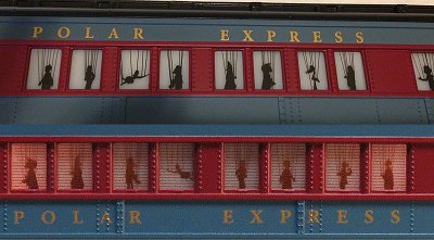 The windows of the Lionel O27 Polar Express scary puppet cars - the original set is on the top and the current version is on the bottom.  Neither makes me want to run this car for children. Click for bigger picture.